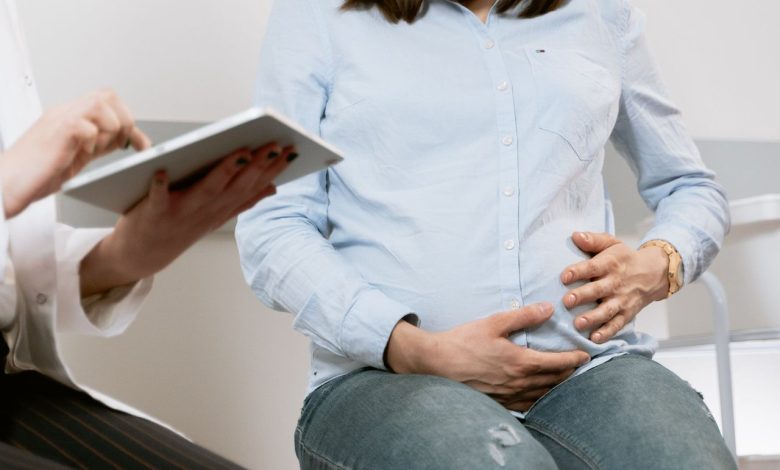 Gestante participa de uma consulta médica em ambiente de atendimento de saúde.