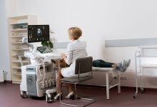 Médica realiza exame de ultrassonografia em uma paciente dentro de uma clínica.